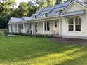 White farmhouse with a long front porch and manicured lawn at 3325 Hopkinson Plantation Rd, Johns Island, SC 29455