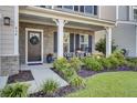 Inviting front porch with stone accents and rocking chairs, enhancing curb appeal at 434 Coopers Hawk Dr, Summerville, SC 29483