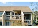 Second-story balcony with wicker chairs and a view of treetops at 1640 Live Oak Park, Seabrook Island, SC 29455