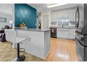 Kitchen with teal feature wall, gray cabinets, and black appliances at 1351 Winifred St, Mount Pleasant, SC 29464