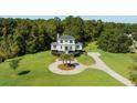 Two-story home with circular driveway and lush green lawn at 7848 Pelican Bay Dr, Awendaw, SC 29429