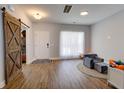 Light-filled entryway with rustic barn door and hardwood floors at 1746 Pierpont Ave, Charleston, SC 29414