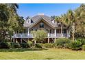 Charming two-story home with a large covered porch, lush landscaping, and beautiful architecture at 3906 Heron Marsh Cir, Johns Island, SC 29455