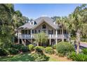 Elegant two-story home boasting a spacious porch, lush landscaping, and a charming facade at 3906 Heron Marsh Cir, Johns Island, SC 29455
