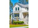 Two-story white farmhouse with gray accents and a charming front porch at 1480 Jeremy Cay Ct, Awendaw, SC 29429