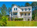 Stunning two-story farmhouse with white siding and gray accents at 1480 Jeremy Cay Ct, Awendaw, SC 29429