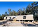 Tan mobile home with black shutters and wooden steps at 0 Marion Rd, Dorchester, SC 29437