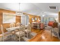 Bright dining area with glass table and white chairs, hardwood floors at 1101 Summerwind Ln, Seabrook Island, SC 29455