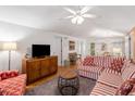 Living room with striped sofa, wood floors and a ceiling fan at 1101 Summerwind Ln, Seabrook Island, SC 29455