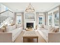 Bright living room with white fireplace, neutral sofas, and large windows at 3559 Clambank Dr, Mount Pleasant, SC 29466