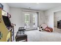 Fun playroom with arcade game, beanbag chairs, and access to a balcony at 229 Camellia Bloom Dr, Moncks Corner, SC 29461