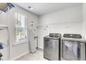 Laundry room with washer, dryer, shelving, and window at 229 Camellia Bloom Dr, Moncks Corner, SC 29461