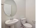 Simple bathroom with pedestal sink, toilet and oval mirror at 1866 Nola Run, Summerville, SC 29485