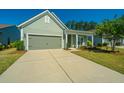 Green house exterior with a two-car garage and a manicured lawn at 145 Hedera Ct, Summerville, SC 29486