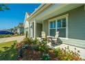 Relaxing covered porch with seating, surrounded by lush landscaping at 145 Hedera Ct, Summerville, SC 29486