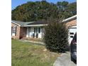 Brick ranch house with solar panels, a porch, and landscaping at 8520 Delhi Rd, North Charleston, SC 29406