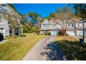 Two-story tan townhouses with green shutters and driveways at 217 Larissa Dr, Charleston, SC 29414