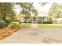 Charming white house with a spacious front porch and well-manicured lawn at 445 Chamblee Rd, Walterboro, SC 29488