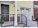 Front exterior of townhome with attached garage, featuring a yellow facade and black door at 104 Summers Creek Ct, Mount Pleasant, SC 29464