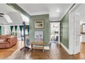 Inviting entryway with brick flooring, green walls, and views into the living room and kitchen at 428 Carn St, Walterboro, SC 29488