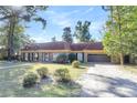 Brick home with brown roof, landscaped lawn, and a gravel driveway at 428 Carn St, Walterboro, SC 29488