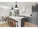 Modern kitchen with dark cabinetry, marble island, and herringbone floors at 3 Penn Ave, Charleston, SC 29407