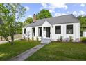 Charming white cottage with gray roof, landscaping, and walkway at 3 Penn Ave, Charleston, SC 29407