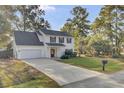 Two-story white house with gray roof, red door, and attached garage at 1600 Windsor Ln, Moncks Corner, SC 29461