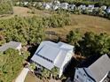 Aerial view of a house with a metal roof in a tree-lined neighborhood at 1999 N Creek Dr, Mount Pleasant, SC 29466