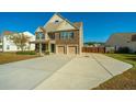Two-story house with stone accents, double garage, and landscaped yard at 551 Rosings Dr, Summerville, SC 29486
