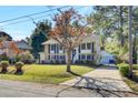 Two-story brick home with blue shutters, landscaped lawn, and driveway at 1525 Westmoreland Ave, Charleston, SC 29412