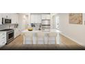 Modern kitchen with white cabinets, an island with seating, and stainless steel appliances at 266 Wappoo Trace Ln, Summerville, SC 29486