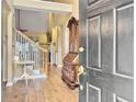 Bright entryway with hardwood floors, staircase, and antique furniture at 2180 Tall Grass Cir, Mount Pleasant, SC 29466