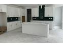 Spacious kitchen with white cabinets and green tile backsplash at 357 Wappoo Trace Ln, Summerville, SC 29486