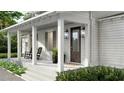 Inviting front porch with rocking chairs and decorative planters at 5209 Seewee Rd, Awendaw, SC 29429