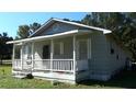Quaint gray home with white shutters, a covered porch, and a spacious yard at 8266 N Highway 17, McClellanville, SC 29458