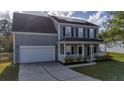 Two story gray house with white garage door and front porch at 417 Crystal Oaks Ln, Moncks Corner, SC 29461