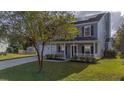 Two story gray house with white garage door and front porch at 417 Crystal Oaks Ln, Moncks Corner, SC 29461