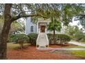 Two-story light blue house with white trim, a front porch, and lush landscaping at 5250 Timber Race Crse, Hollywood, SC 29449