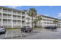 Multi-story building with ample parking and palm trees at 93 Mariners Cay Drive, Folly Beach, SC 29439