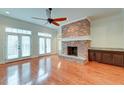 Gathering room features hardwood floors, a brick fireplace, and French doors leading to the backyard at 106 Aviary Ct, Summerville, SC 29483