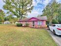 Brick ranch house with pink accents and a spacious yard at 100 Shamrock Dr, Summerville, SC 29483