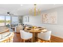 Bright dining area with wooden table and white chairs, hardwood floors, and a modern chandelier at 1665 A Marsh Harbor Ln, Mount Pleasant, SC 29464