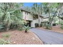 Exterior view of a charming two-story house with lush landscaping and a driveway at 1111 Summerwind Lane, Seabrook Island, SC 29455