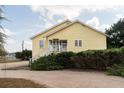 Side view of yellow house with screened porch and hedges at 2302 Palmetto Blvd, Edisto Beach, SC 29438