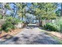 Gravel driveway with wooden gates leading to a house at 247 Holbrook Dr, Ladson, SC 29456