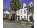 Three-story brick and white townhouses with palm trees and landscaped yards at 752 Certificate Ct, Charleston, SC 29414
