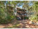 Elevated home with screened porches and decks nestled in a wooded area at 362 Pelican Flight Dr, Dewees Island, SC 29451