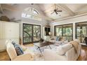 Living room with vaulted ceilings, hardwood floors, and access to a deck at 362 Pelican Flight Dr, Dewees Island, SC 29451