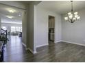 Bright dining room with hardwood floors and chandelier, view into living room and kitchen at 415 Snowy Plover Ln, Summerville, SC 29486